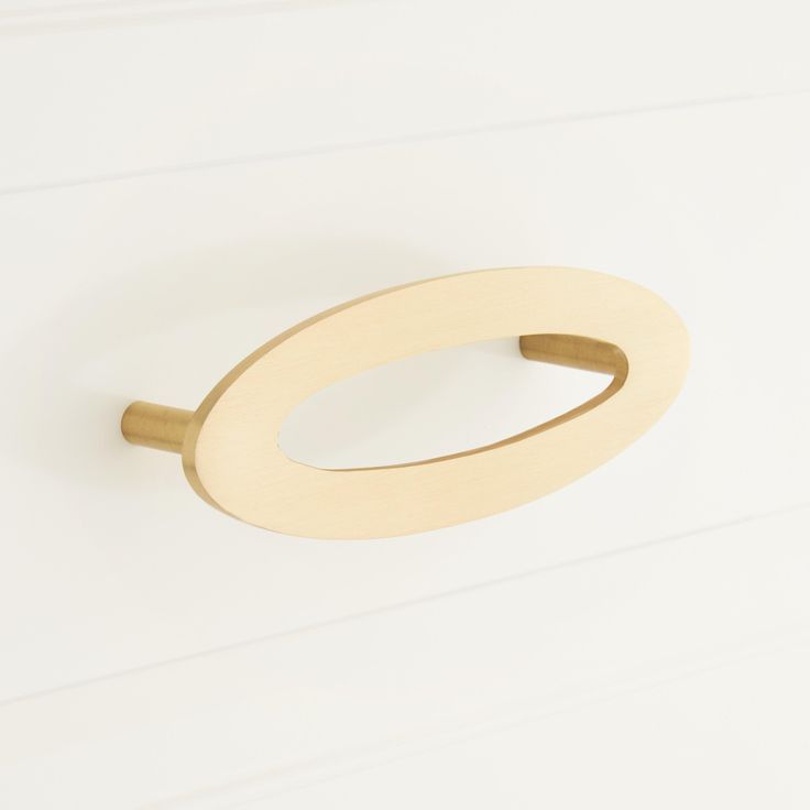 an oval wooden handle on a white wall