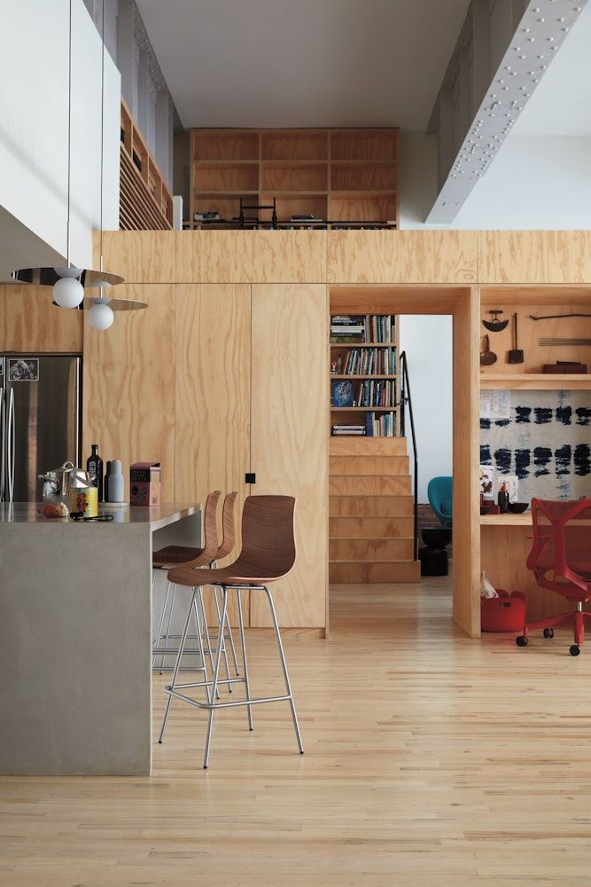 an open kitchen and living room with wood paneling