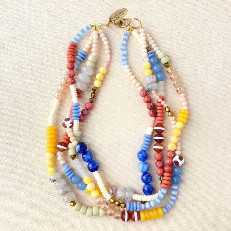 Achieve that stacked look effortlessly with this boho chic style layered statement necklace. An array of vibrant colorful semi-precious and glass beads strung on 4 strands that have been twisted for a fuller attention-grabbing stacked layered look. 20"L. Lobster clasp. Handmade in USA. Colorful Multi-strand Czech Glass Beaded Jewelry, Multi-strand Czech Glass Colorful Beads Jewelry, Colorful Multi-strand Czech Glass Beaded Necklaces, Colorful Multi-strand Czech Glass Bead Necklace, Multi-strand Colorful Czech Glass Beaded Necklaces, Multi-strand Czech Glass Necklaces With Colorful Beads, Multi-strand Czech Glass Beaded Necklace, Multi-strand Czech Glass Colorful Beads Necklace, Bohemian Double Strand Necklace With Faceted Beads