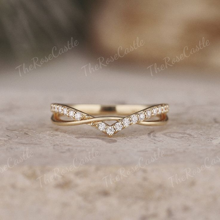 a yellow gold wedding band with three small diamonds in the middle, set on top of a stone surface