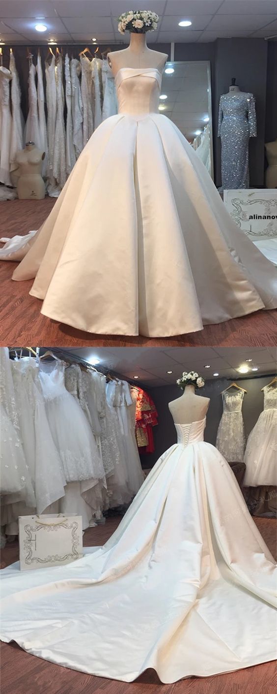 the wedding dress is on display in front of other bridal gowns and dresses