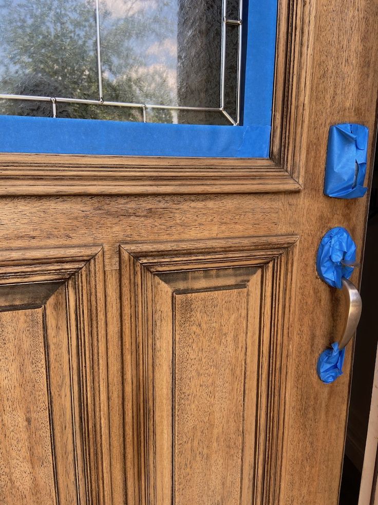 a close up of a wooden door with blue tape on the front and side panels