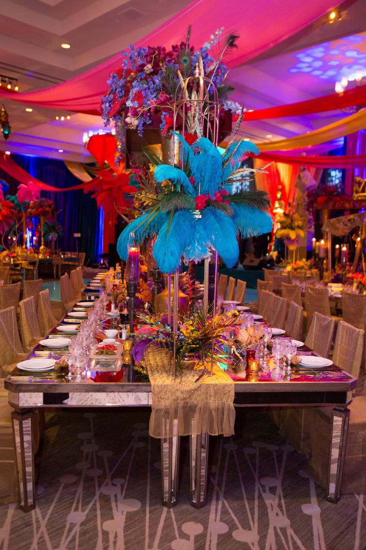 a table set up for a party with blue and red decorations on it, surrounded by chairs