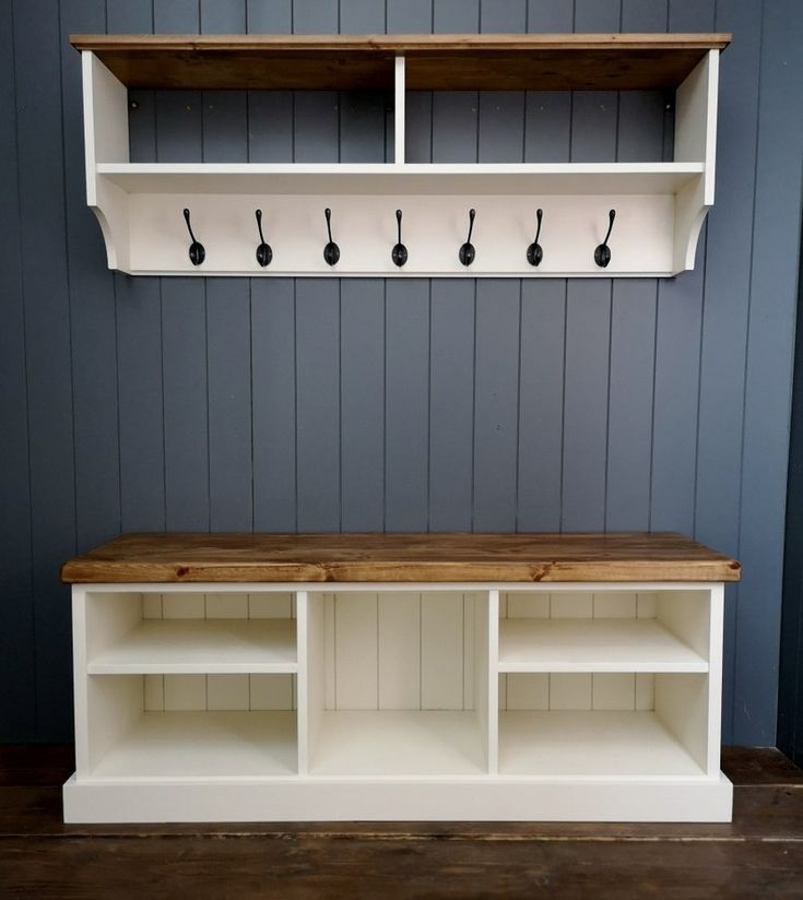 a white shelf with some hooks on it and a wicker basket in front of it