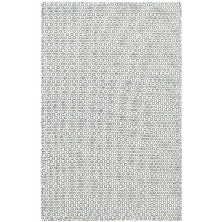 a white and grey rug with small circles on the bottom, in front of a white background