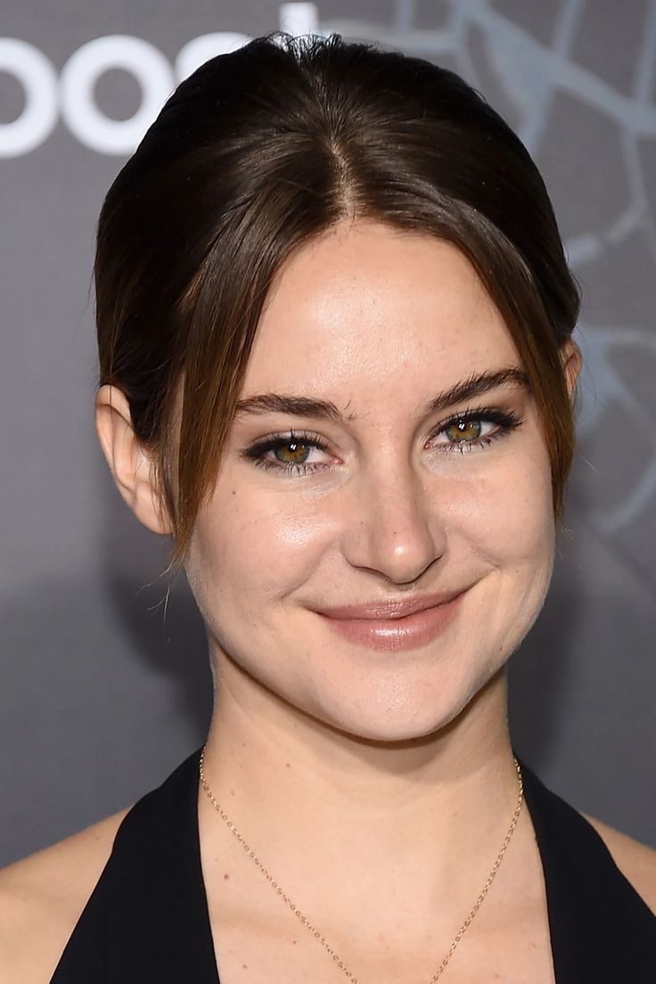 a close up of a person wearing a black dress and smiling at the camera with an embellished smile on her face