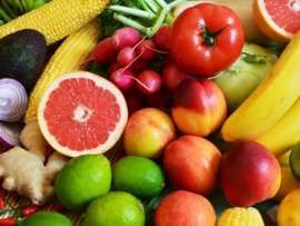 an assortment of fresh fruits and vegetables are shown in this close up photo, including bananas, oranges, melons, limes, corn