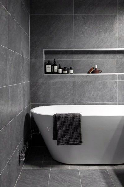 a white bath tub sitting in a bathroom next to a shelf