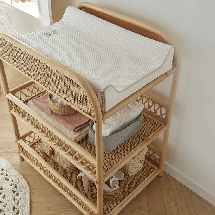 a baby crib with baskets and blankets on it