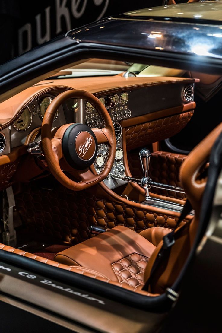 the interior of an old car with wood trim and leather seats, including steering wheel