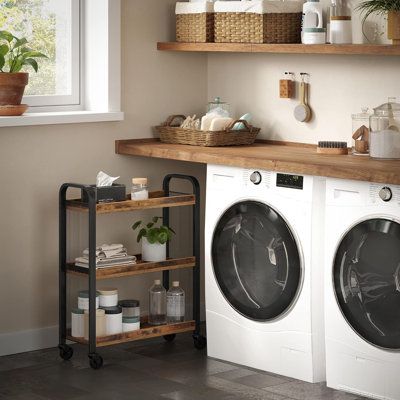 a washer and dryer sitting in a room next to a shelf with plants