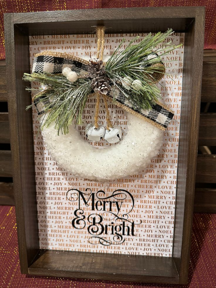 a christmas ornament hanging in a wooden frame