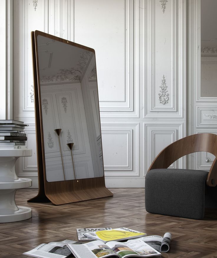 a mirror sitting on top of a wooden floor next to a chair