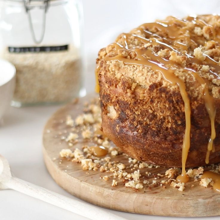 a cake with icing drizzled over it sitting on a wooden board