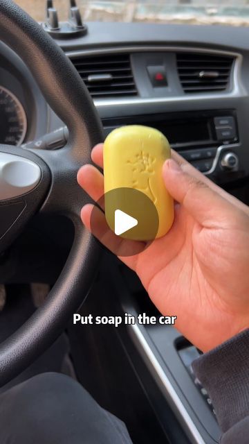 a person holding a soap in their hand while sitting in the driver's seat