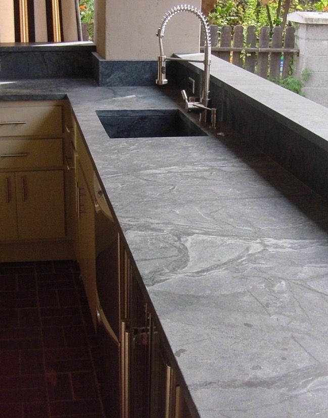 a kitchen counter top with two sinks and a faucet