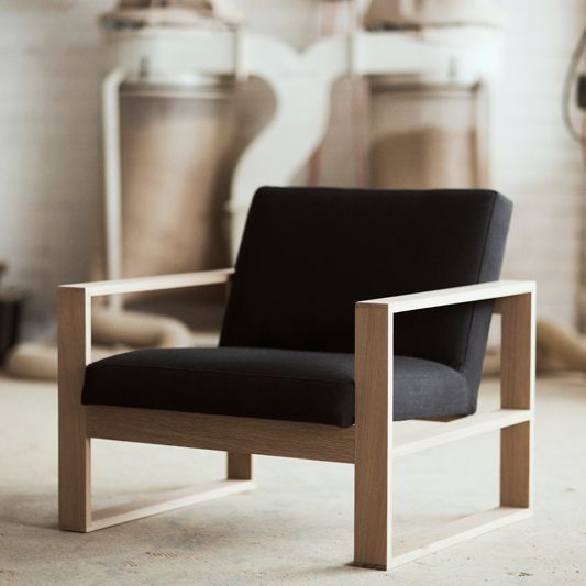 a black chair sitting on top of a white floor next to a wall mounted mixer