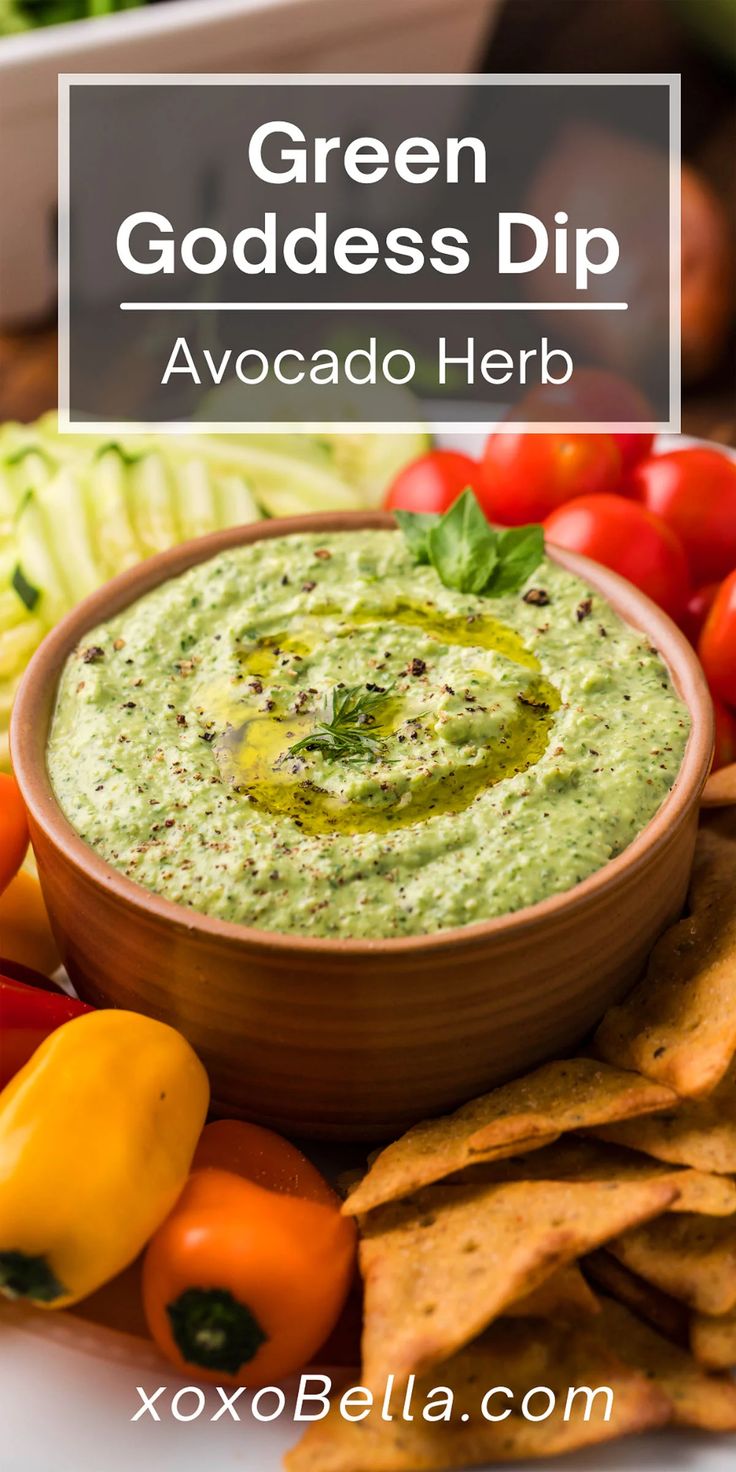 avocado herb green goddess dip recipe in a bowl surrounded by vegetables and tortilla chips