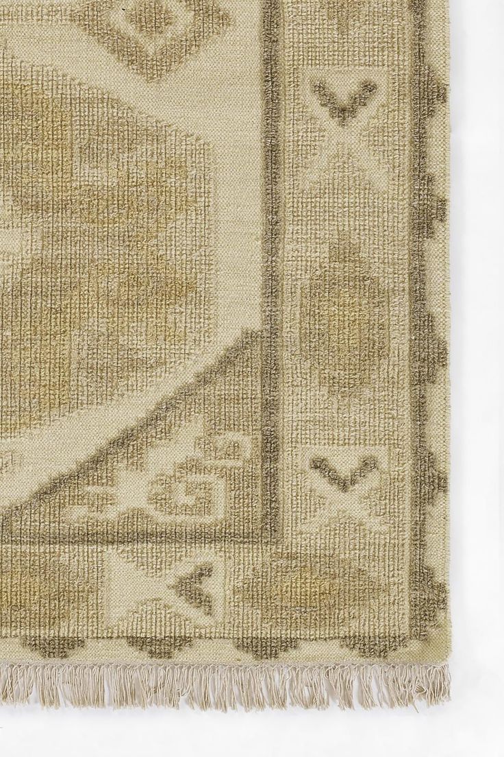 an old rug with fringes on the edges and a design in grey, beige and white