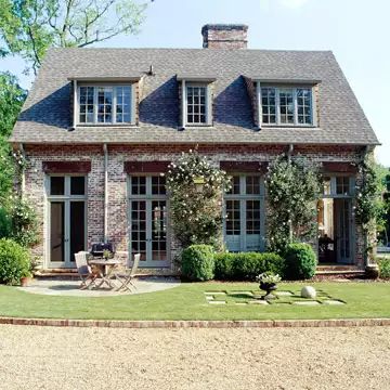 a large house sitting on top of a lush green field