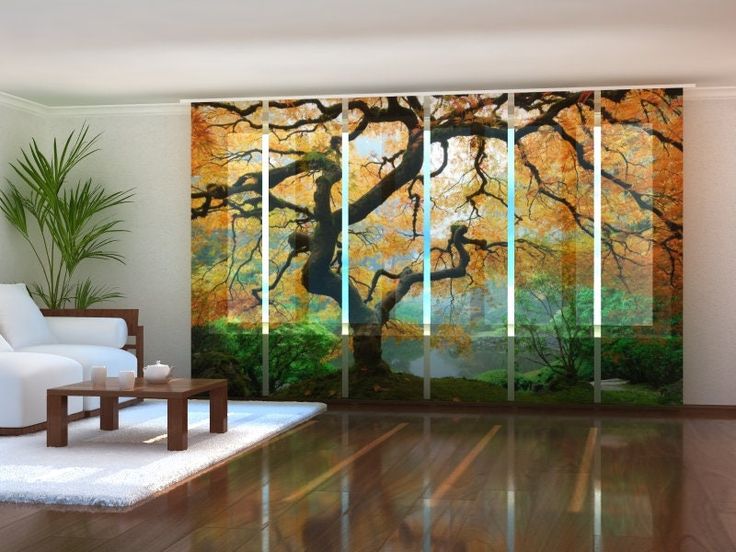 a living room with white furniture and an artistic painting on the sliding glass door doors