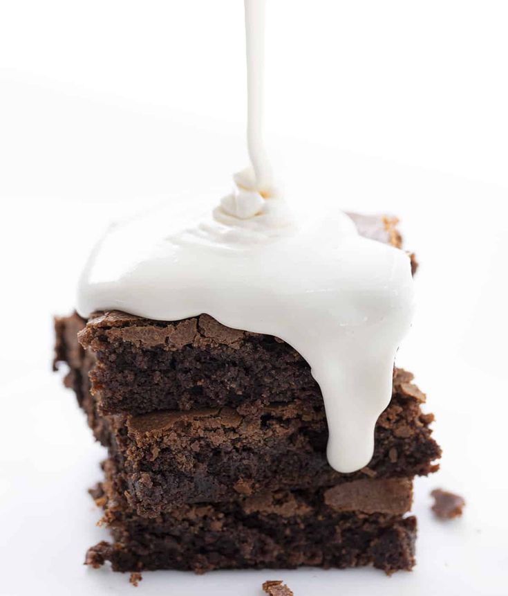 a piece of chocolate cake with white icing on top