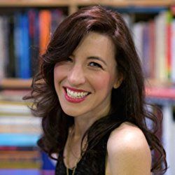 a smiling woman sitting in front of a bookshelf