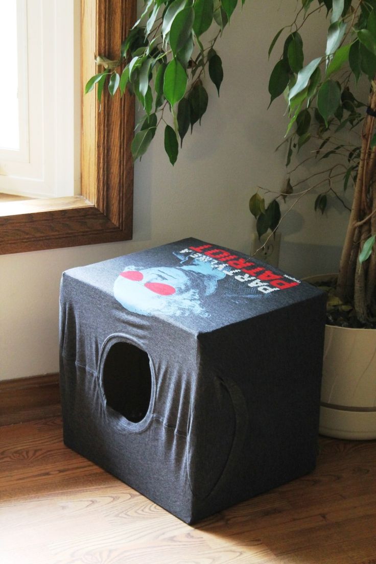 a black box sitting on top of a wooden floor next to a potted plant