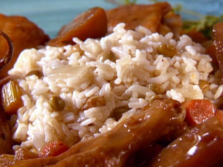 a plate topped with rice and meat covered in sauce