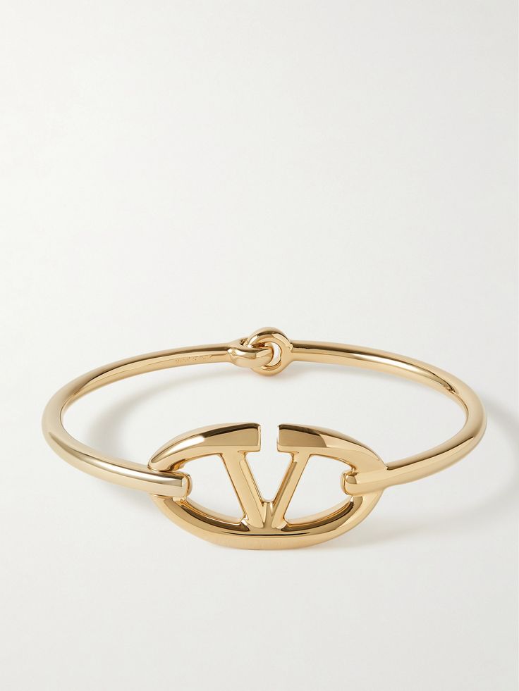 Valentino Garavani's bracelet makes such a pretty set with the matching earrings and choker in our edit. Made in Italy from gold-tone metal, it has a slim band adorned with the house's instantly recognizable 'VLOGO' at its center. Luxury Gold-plated Jewelry With Gold-tone Logo, Designer Metal Jewelry, Gold-tone Plated Jewelry With Logo Plaque, Modern Jewelry With Gold-tone Logo Plaque As Gift, Modern Gift Jewelry With Gold-tone Logo Plaque, Yellow Gold Metal Jewelry With Gold-tone Logo, Designer Yellow Gold Jewelry With Logo, Designer Yellow Gold Jewelry With Polished Finish, Designer Gold-tone Metal Jewelry