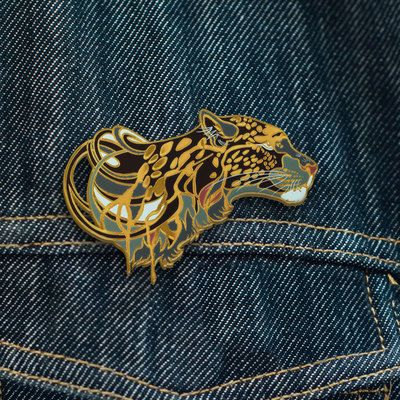 a gold and black tiger head on the back of a pair of blue denim jeans