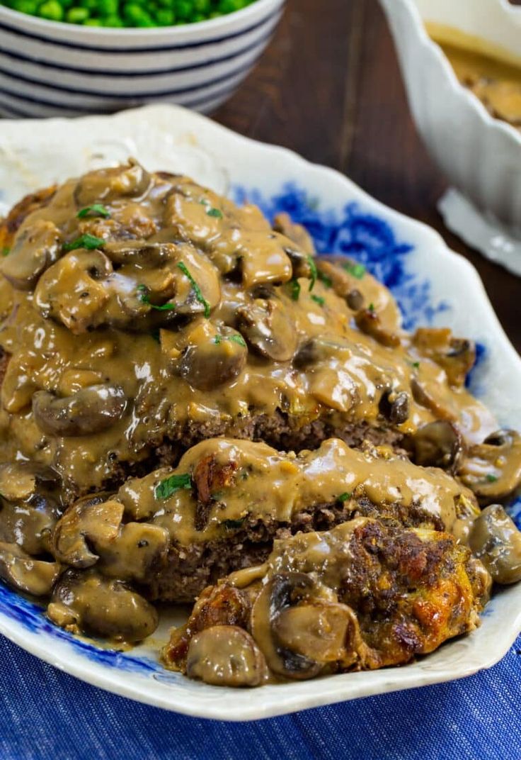 a blue and white plate topped with meat covered in gravy