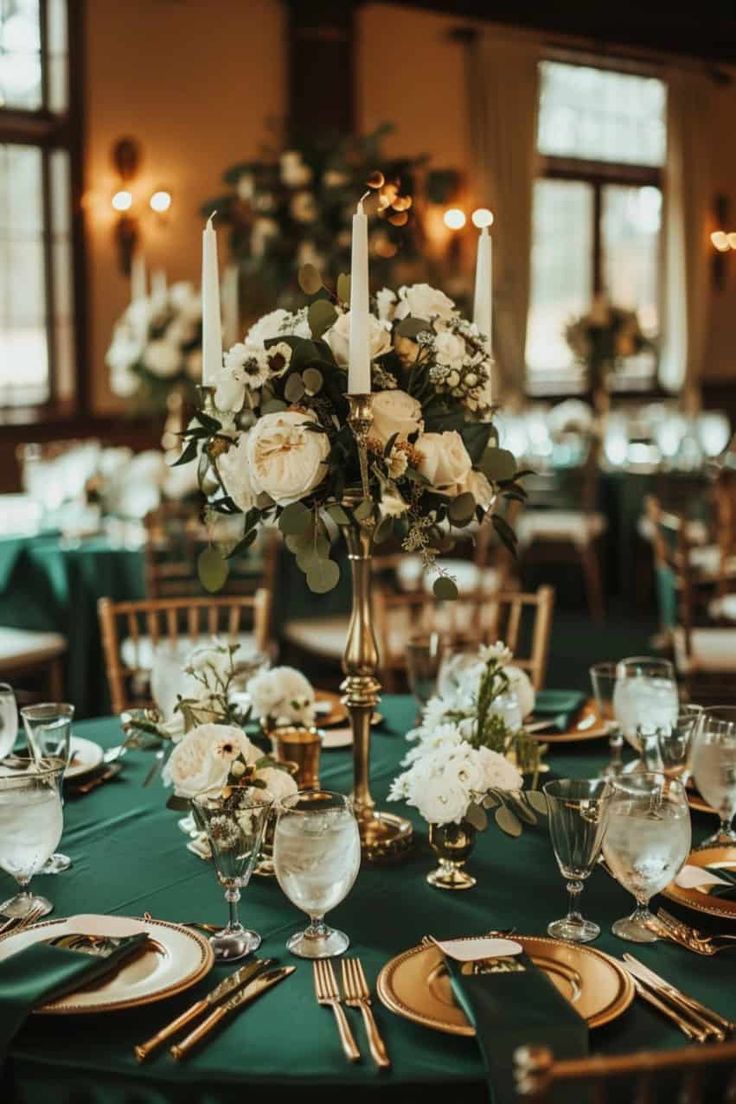 the centerpieces on this table are adorned with white flowers and greenery