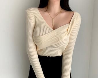 Elegant Ribbed Winter White Top, Elegant Winter White Fine Knit Top, Chic Knitted Tops For Layering, Cream Fine Knit V-neck Top, Chic Cream Winter Tops, Chic Cream Winter Top, Elegant Cream Ribbed Tops, Elegant Knitted Crew Neck Top, Trendy Knitted Tops For Layering