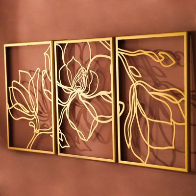 three metal artwork pieces hanging on the wall