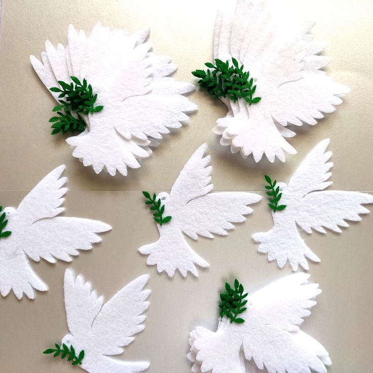 six white paper birds with green leaves on them