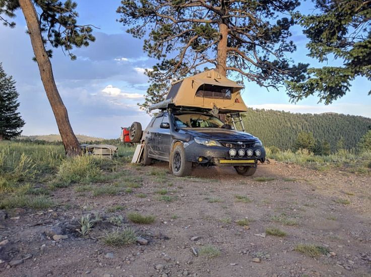 a truck with a camper attached to it parked on a dirt road