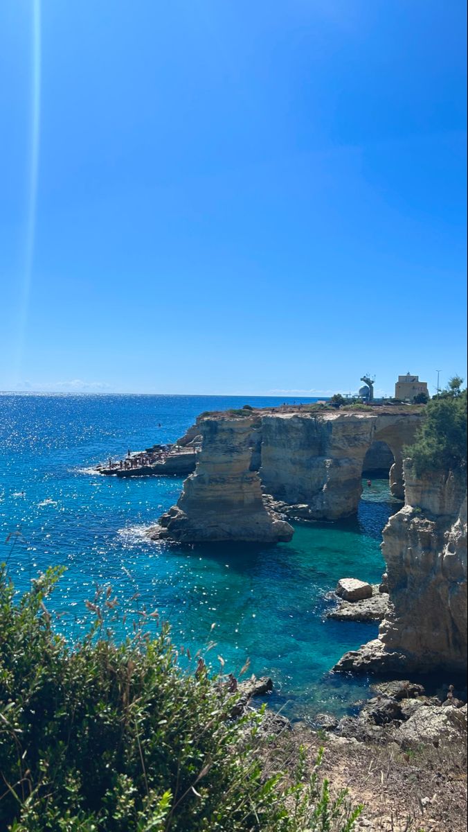 the water is crystal blue and clear with some cliffs in the backgrouds