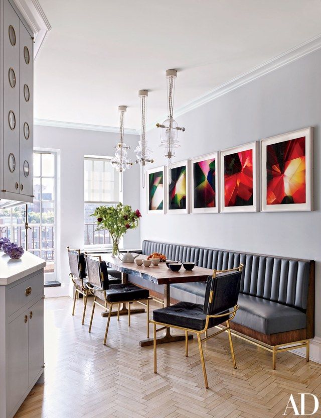 a dining room table with chairs and pictures on the wall