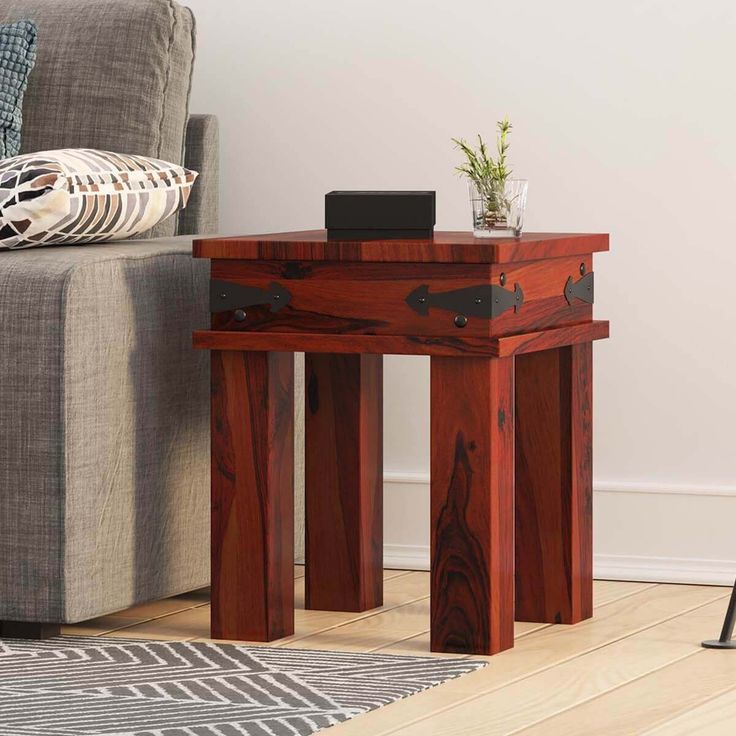 a small wooden table sitting on top of a hard wood floor next to a couch