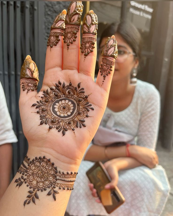 a woman's hand with henna tattoos on it