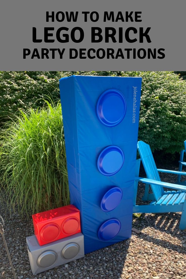 a blue and red lego block sitting in the middle of a yard next to a bench