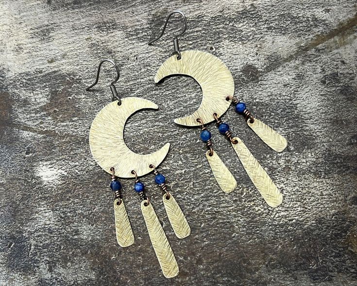 Unusual handmade blue stone earrings for woman. This healing jewelry with kyanite will be perfect for nature lovers. Special occasion celestial jewellery will be ideal for extraordinary gift. These ethnic and elegant nature-inspired earrings will be perfect for evening outings and parties. The unique gemstone earrings will be perfect for a forest and country style wedding or festival ceremony. You can also wear them for a walk with your dog. Product dimensions - Earrings' length (together with clasp): approx. 7.5 cm / 3.0 in - Earrings' width: approx. 2.5 cm / 1.0 in - Ear wires/clasp: surgical steel, hypoallergenic metal Beautiful earrings were made of alpacca metal in silver colour. The shape of the earrings has been hand cut. The earrings are really lightweight and made using the hammer Blue Handmade Spiritual Earrings, Handmade Blue Spiritual Earrings, Handmade Bohemian Kyanite Jewelry, Artisan Blue Brass Earrings, Blue Brass Earrings With Natural Stones, Blue Earrings With Natural Stones, Nature-inspired Blue Dangle Earrings, Handmade Celestial Sapphire Jewelry, Blue Moonstone Earrings With Natural Stones