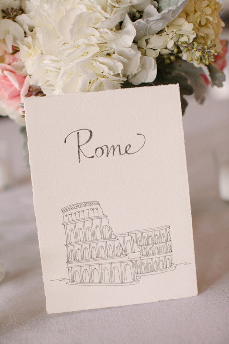 a bouquet of flowers sitting on top of a table next to a card with the word rome