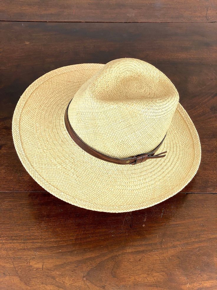 Wide brim fedora panama hat made in natural straw in natural color. Finished with an eco leather belt. Beautiful summer hat for men and woman. The measurements in centimeters are 36 x 34. Brim length 9.5. (These measurements may vary slightly depending on the size of the hat) For its elaboration we only use hoods and capelines of resistant natural straw (genuine paja toquilla) of very good quality. In our workshop in the Pyrenees we sew and make one by one our hats with wooden molds of our own d Summer Fedora Panama Hat Made Of Palm Leaf, Brimmed Beige Panama Hat For Travel, Beige Brimmed Panama Hat For Travel, Classic Brimmed Hats For Vacation, Country Style Toquilla Straw Hat For Travel, Western Flat Bill Hat For Beach, Classic Curved Brim Hat For Vacation, Summer Panama Hat For Rodeo With Flat Bill, Western Flat Bill Hat For The Beach