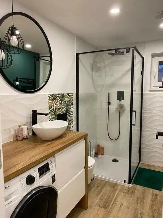 a washer and dryer in a bathroom with a sink, mirror, and shower