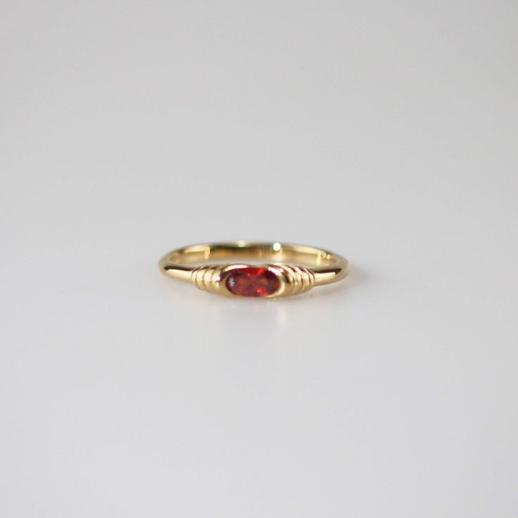 This exquisite Garnet Slim Ring features a vibrant red gemstone at its center, encased within a setting that beautifully highlights its rich color and sparkle. The band is elegantly adorned with intricate patterns. This stunning ring is perfect for special occasions or everyday wear, and makes a beautiful addition to any collection. 18k gold plated Stainless steel base Waterproof and tarnish free Available in US 6-8 Ring sizing chart Classic Ruby Ring With Gemstone Accents For Promise, Fine Jewelry Red Ruby Ring, Formal Red Oval Sapphire Ring, Formal Red Sapphire Ring With Oval Shape, Heirloom Red Jewelry With Gemstone Accents, Red Heirloom Jewelry With Gemstone Accents, Classic Red Promise Ring, Heirloom Red Gemstone Jewelry, Red Garnet Round Band Jewelry