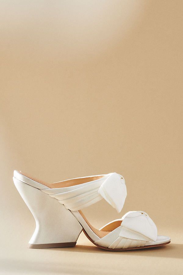 The Dee Ocleppo Burgundy Satin Bows Mule Sandals exude luxurious femininity with their rich satin and bold bow embellishments, making them the perfect statement footwear for any elegant occasion. | Burgundy Satin Bows Mule Sandals by Dee Ocleppo in White, Women's, Size: 40, Leather/Satin at Anthropologie Bow Embellishments, Bow Mules, Mule Sandals, Color Rojo, Mules Shoes, Mule, Embellishments, Tacos, Anthropologie