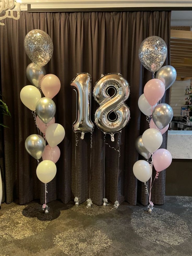 balloons and streamers are arranged in the shape of the number twenty eight, surrounded by silver and pink balloons