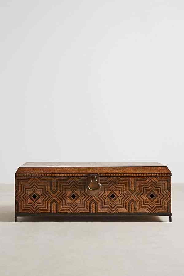 a wooden box with an intricate design on the front and sides, sitting on a white surface